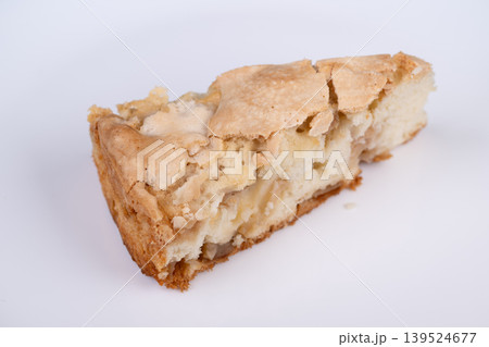 Fresh baked apple treat on plate. Warm rustic apple tart served under natural lighting. Homemade apple charlotte slice displayed on white dish with inviting atmosphere Fresh baked apple treat on plate. Warm rustic apple tart served under natural lighting. Homemade apple charlotte slice displayed on white dish with inviting atmosphere 139524677