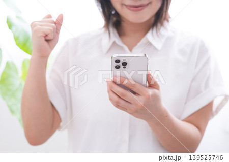 スマホを持ってガッツポーズする女性 スマホを持ってガッツポーズする女性 139525746