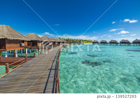 Stunning Maldives water villas over turquoise lagoon, overwater bungalows on tropical pier extending into calm ocean, luxury travel destination, idyllic paradise resort, serene tropical escape, scenic Stunning Maldives water villas over turquoise lagoon, overwater bungalows on tropical pier extending into calm ocean, luxury travel destination, idyllic paradise resort, serene tropical escape, scenic 139527203
