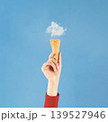 Hand holding ice cream cone with cloud 139527946