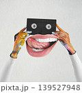 Creative hands holding retro cassette with funny mouth 139527948