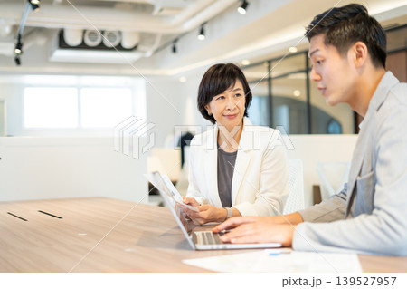 打合せをするシニア女性と若いビジネスマン 打合せをするシニア女性と若いビジネスマン 139527957