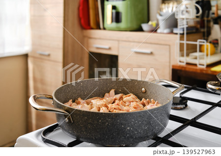 Cooking chicken in a kitchen using a stovetop pot during afternoon hours Cooking chicken in a kitchen using a stovetop pot during afternoon hours 139527963