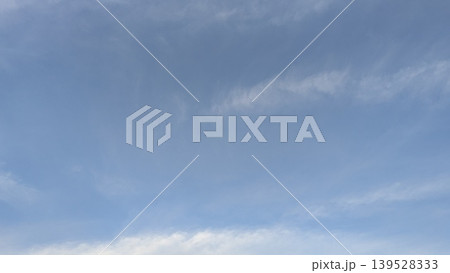 A serene image of a pale blue sky with light, wispy clouds stretching across the frame. The subtle white streaks and patches create a sense of calm and openness. A serene image of a pale blue sky with light, wispy clouds stretching across the frame. The subtle white streaks and patches create a sense of calm and openness. 139528333