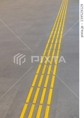Yellow tactile paving tiles in airport terminal 139529129