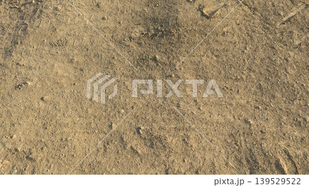 Dry brown soil features rough textures, scattered stones. This natural earth background captures agricultural land under warm sunlight. Perfect for farming, construction themes. 139529522