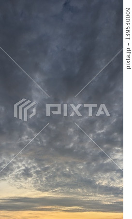 Dark storm clouds fill the morning sky, glowing with orange sunrise light at the horizon. This dramatic atmosphere captures natural weather transitions, moody dawn textures, scenic outdoor views. Dark storm clouds fill the morning sky, glowing with orange sunrise light at the horizon. This dramatic atmosphere captures natural weather transitions, moody dawn textures, scenic outdoor views. 139530009