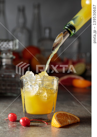 Orange juice poured into a glass with ice. 139530687