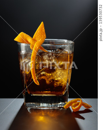 Old fashioned cocktail in a sweating glass on a black table. Old fashioned cocktail in a sweating glass on a black table. 139530732