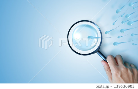 Hand holding magnifying glass focusing on 3D human sperm cells and female egg on blue background. Medical research concept of male fertility test, reproductive health, IVF, and quality analysis. Hand holding magnifying glass focusing on 3D human sperm cells and female egg on blue background. Medical research concept of male fertility test, reproductive health, IVF, and quality analysis. 139530903