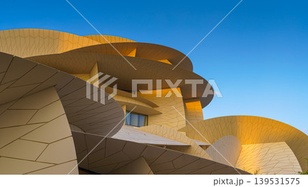 Doha, Qatar - Jan 06 2024, a panoramic view of National Museum of Qatar facade, exterior, shaped like a desert rose, at evening with blue sky, Doha, Qatar Doha, Qatar - Jan 06 2024, a panoramic view of National Museum of Qatar facade, exterior, shaped like a desert rose, at evening with blue sky, Doha, Qatar 139531575