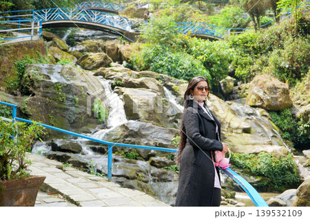 Beautiful young woman enjoying the scenic beauty of the Rock Garden waterfall in Darjeeling Beautiful young woman enjoying the scenic beauty of the Rock Garden waterfall in Darjeeling 139532109