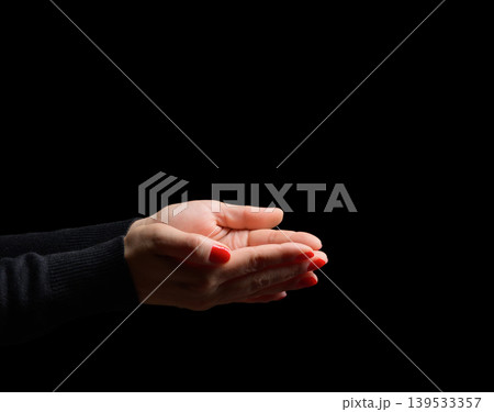 Two female palms with bright red manicure folded together in a pleading or holding gesture Two female palms with bright red manicure folded together in a pleading or holding gesture 139533357