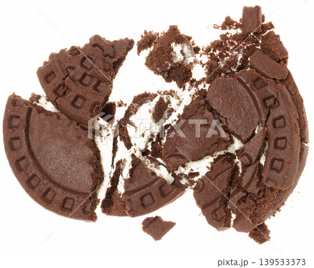 Broken chocolate chip cookies with white cream filling on white background 139533373