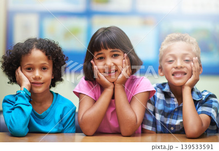 Students, friends and portrait or happiness in classroom for learning, knowledge or education at desk. Kids, face and smile at academy or school with confidence or pride for development and diversity Students, friends and portrait or happiness in classroom for learning, knowledge or education at desk. Kids, face and smile at academy or school with confidence or pride for development and diversity 139533591