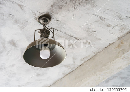 Industrial ceiling lamp, led bulb with an iron shade on textured concrete loft ceiling background Industrial ceiling lamp, led bulb with an iron shade on textured concrete loft ceiling background 139533705