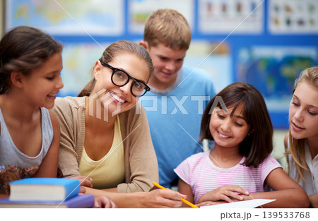 Happy teacher, students and writing for learning, education or tutoring in classroom at school. Woman, mentor or educator helping young kids or children with books for studying or literature in class Happy teacher, students and writing for learning, education or tutoring in classroom at school. Woman, mentor or educator helping young kids or children with books for studying or literature in class 139533768