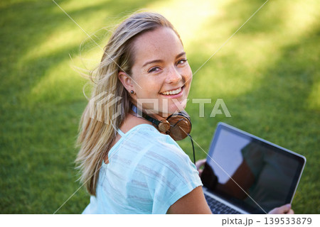 College, portrait and student with laptop on grass working on research outdoor in park. University, campus and happy woman with computer, headphones and smile for writing notes on project for class College, portrait and student with laptop on grass working on research outdoor in park. University, campus and happy woman with computer, headphones and smile for writing notes on project for class 139533879