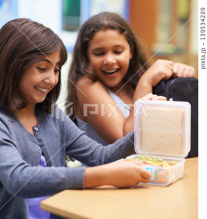 Happy girl, friends and student with lunchbox for eating meal, break or snack time in classroom at school. Young kids or elementary children smile for container, food or fiber and nutrition in recess 139534289