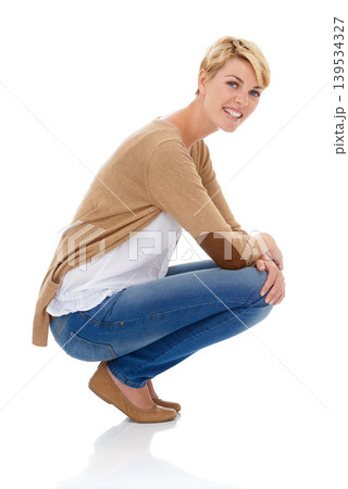 Happy woman, portrait and sitting in casual fashion or pose isolated on a white studio background. Young female person, model or blonde smile with denim jeans or clothing in relax on mockup space Happy woman, portrait and sitting in casual fashion or pose isolated on a white studio background. Young female person, model or blonde smile with denim jeans or clothing in relax on mockup space 139534327