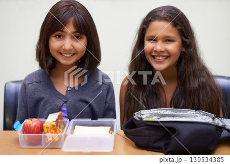 Girl, friends and portrait with lunch at school for recess, break or nutrition at table and happy. Kids, face and smile at academy or relax with confidence, food or pride for childhood development Girl, friends and portrait with lunch at school for recess, break or nutrition at table and happy. Kids, face and smile at academy or relax with confidence, food or pride for childhood development 139534385