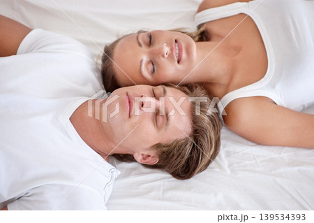 Sleeping, love and young couple on bed in modern apartment relaxing together in the morning. Happy, calm and man and woman in marriage taking comfortable nap for dreaming in bedroom at home or house. 139534393