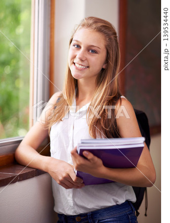 Happy woman, portrait and student with book at school hallway for education, study or learning. Young female person or teenager smile with textbooks and backpack for academic studying or knowledge Happy woman, portrait and student with book at school hallway for education, study or learning. Young female person or teenager smile with textbooks and backpack for academic studying or knowledge 139534440