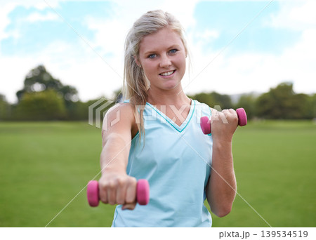 Woman, portrait and dumbbell outdoor for weightlifting with smile for workout, training or fitness on field. Athlete, person and happy for physical activity or healthy body on grass with equipment Woman, portrait and dumbbell outdoor for weightlifting with smile for workout, training or fitness on field. Athlete, person and happy for physical activity or healthy body on grass with equipment 139534519