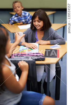 School, students or girl with a phone for a secret, gossip or rude message online in classroom. Show news, share info or happy children with picture on mobile app or social media for cyber bullying School, students or girl with a phone for a secret, gossip or rude message online in classroom. Show news, share info or happy children with picture on mobile app or social media for cyber bullying 139534557