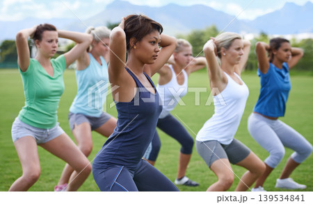 Women, stretching and squats for exercise outdoor, team and ready for workout with health and wellness. Training together on sports field, young athlete group warm up and fitness in the park Women, stretching and squats for exercise outdoor, team and ready for workout with health and wellness. Training together on sports field, young athlete group warm up and fitness in the park 139534841