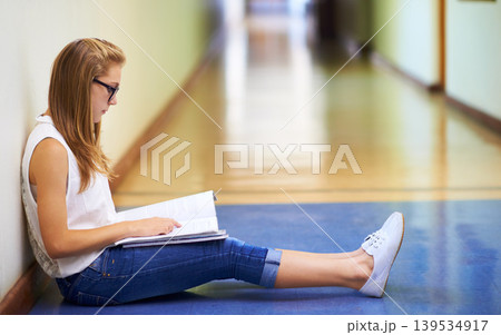 Woman, teenager and student reading book in hallway at school for learning, education or studying. Female person or young child or kid sitting on floor in corridor with textbook outside classroom Woman, teenager and student reading book in hallway at school for learning, education or studying. Female person or young child or kid sitting on floor in corridor with textbook outside classroom 139534917