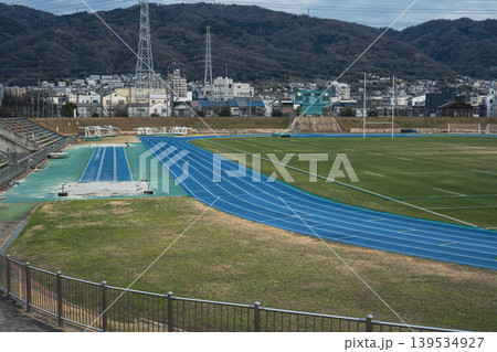 街並みと山を背景に広がる陸上競技場 街並みと山を背景に広がる陸上競技場 139534927