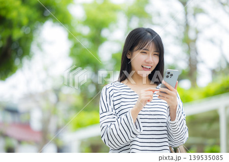 屋外でスマホを操作する若い女性 139535085