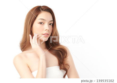 A beautiful young Asian woman with clean, fresh skin against a white background. Skincare, facial treatment, cosmetology, beauty, and spa. An elegant portrait of an Asian woman. 139535102