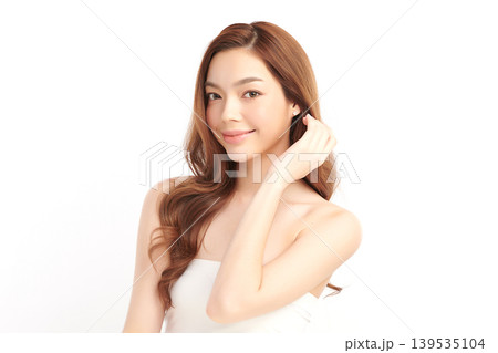 A beautiful young Asian woman with clean, fresh skin against a white background. Skincare, facial treatment, cosmetology, beauty, and spa. An elegant portrait of an Asian woman. 139535104