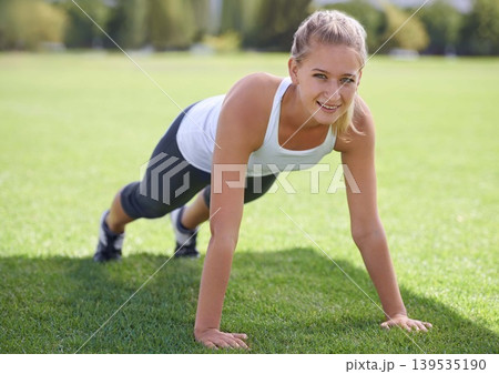 Women, portrait and push ups on grass for fitness with exercise, training and workout on sports field. Athlete, person and confidence on ground with physical activity for healthy body and wellness Women, portrait and push ups on grass for fitness with exercise, training and workout on sports field. Athlete, person and confidence on ground with physical activity for healthy body and wellness 139535190