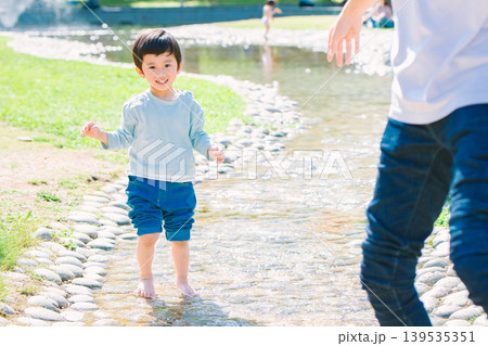 夏の小川で遊ぶ親子 夏の小川で遊ぶ親子 139535351