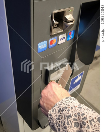 A woman's hand places a gold bank card on a self-service terminal to make a payment A woman's hand places a gold bank card on a self-service terminal to make a payment 139535848