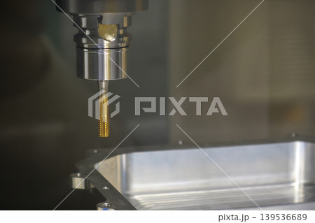 Close-up of a special-purpose tapping tool during the high-precision internal thread-making process for automotive parts. Close-up of a special-purpose tapping tool during the high-precision internal thread-making process for automotive parts. 139536689