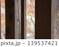 木の縦格子の隙間に広がる紅葉のボケ 139537421