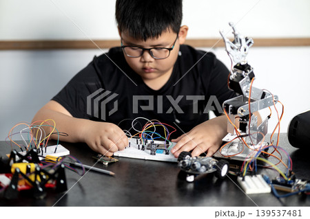 boy having fun connecting electronic circuit board boy having fun connecting electronic circuit board 139537481