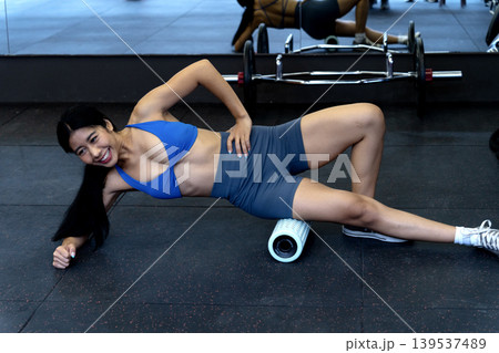 In the fitness center young woman is exercising while lying down using a circular In the fitness center young woman is exercising while lying down using a circular 139537489