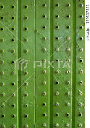 Light green perforated iron surface with rust spots. 139537521