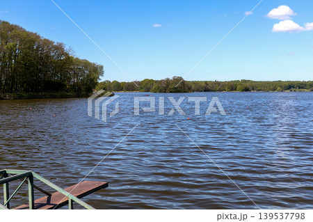 Blue lake water and peaceful nature landscape under clear sky in Denmark. Blue lake water and peaceful nature landscape under clear sky in Denmark. 139537798