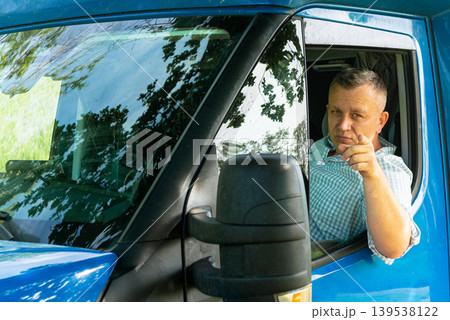 Truck driver looking out of cab window 139538122