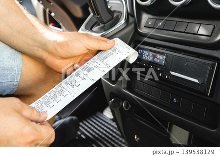Detailed view of tachograph paper printout in hand 139538129