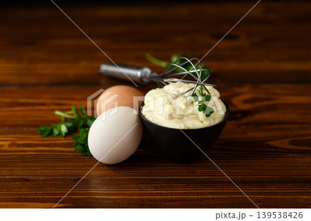 Homemade mayonnaise with herbs and eggs on a wooden background Homemade mayonnaise with herbs and eggs on a wooden background 139538426