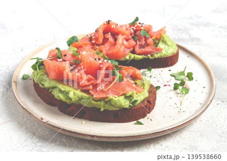 breakfast, Sandwiches with smoked salmon and avocado, on dark rye bread, with microgreens, on a marble table, homemade, no people, 139538660