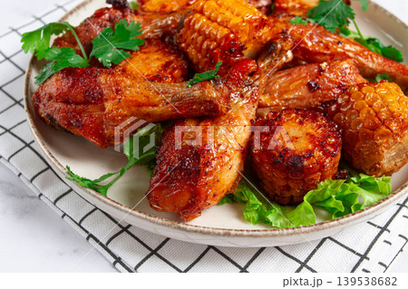 Fried chicken drumsticks, Mexican style, with corn, on a plate, close-up, Fried chicken drumsticks, Mexican style, with corn, on a plate, close-up, 139538682