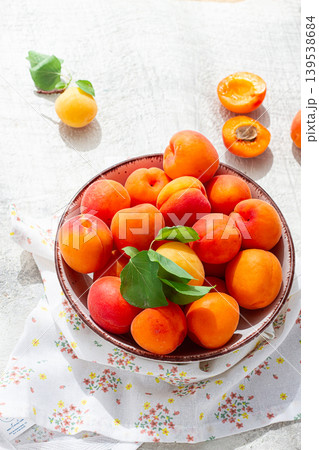 Fresh apricots in a bowl, on a bright table, natural light, top view, no people, 139538684